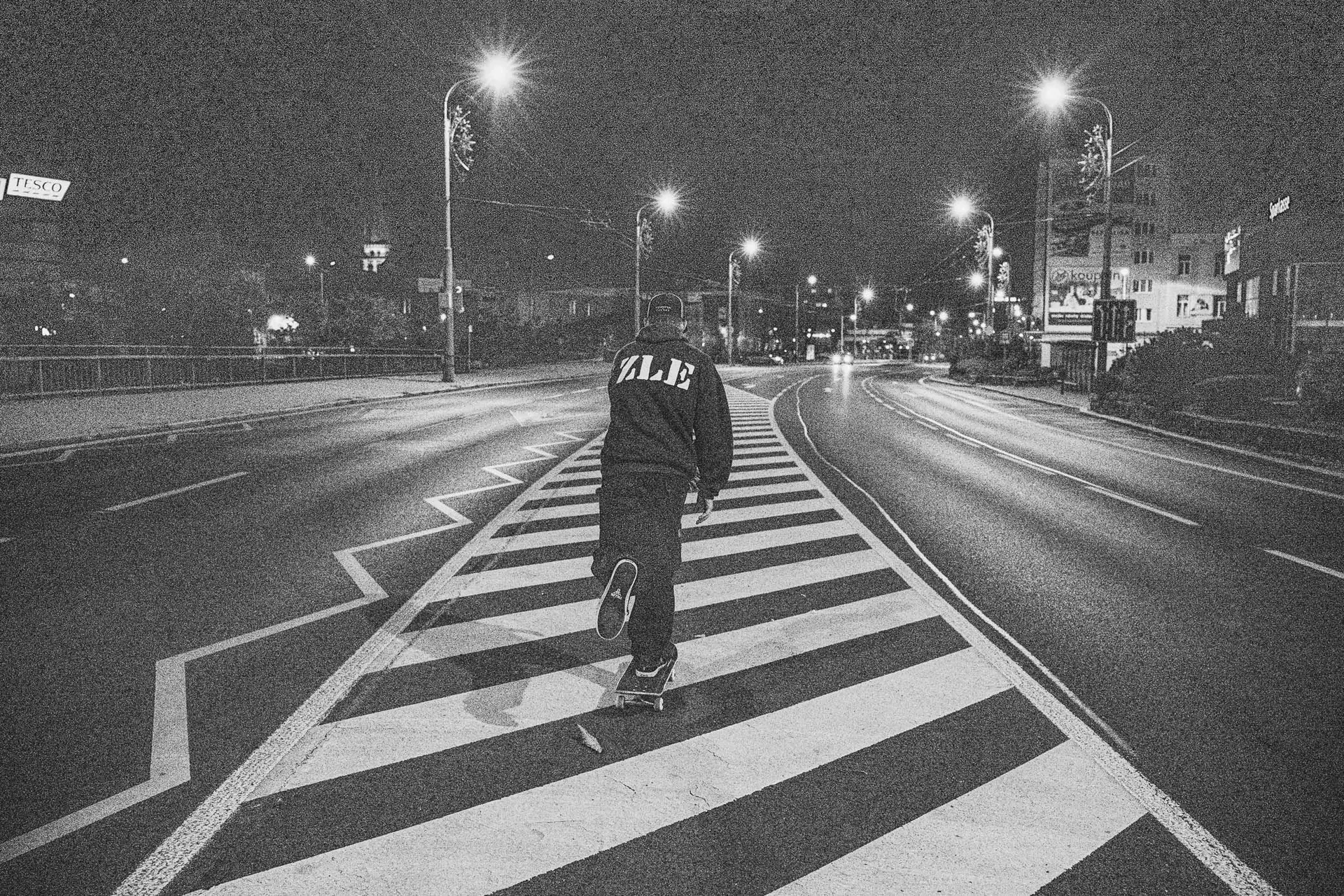 Skateboardista jede po přechodu prázdnou noční ulicí v Plzni